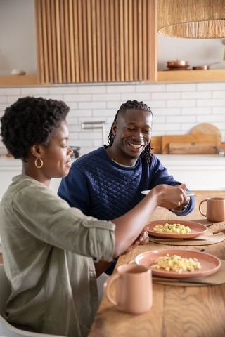 Couple enjoys breakfast with scrambled eggs in modern kitchen