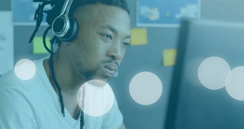 Young Professional With Headphones Focusing At Work Desk