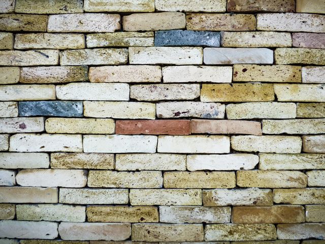 Close-up of vintage brick wall showcasing various colors and patterns. Ideal use for backgrounds, backdrops in construction, architecture, real estate advertisements, and interior design visualizations. Excellent for illustrating building materials or historical buildings.