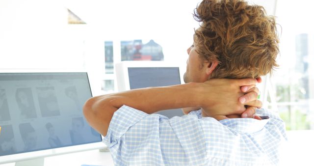 Tired Businessman Stretching at Desk with Multiple Monitors - Download Free Stock Images Pikwizard.com