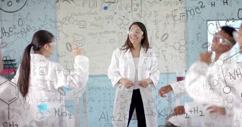 Female Chemistry Teacher Teaching Students in Lab with Molecular Diagrams and Goggles