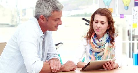 Casual Business Partners Collaborating Using Tablet in Modern Office