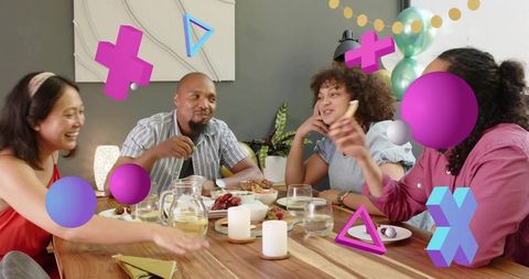 Friends laughing and sharing food at cozy dinner party with playful 3D graphic overlays