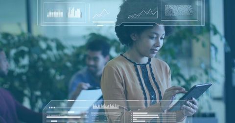 Woman tapping tablet with hud dashboards and analytics in open-plan workspace