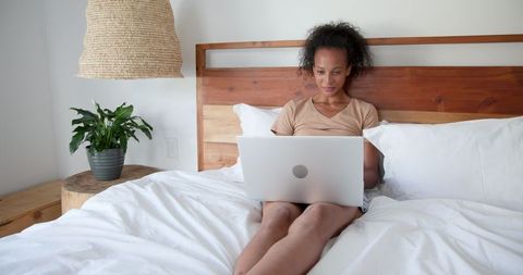 Woman Using Laptop in Minimalist Boho Bedroom