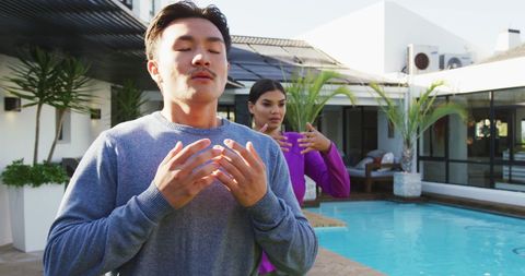 Diverse Couple Practicing Tai Chi in Contemporary Garden