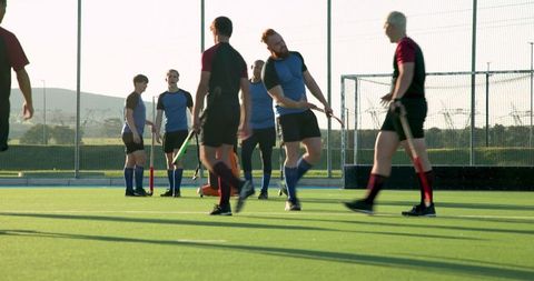 Dynamic Male Field Hockey Players Engaging in Team Exercise on Turf