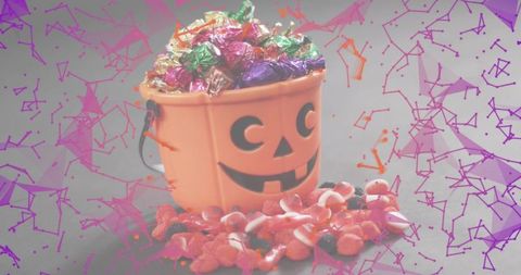 Halloween Jack-o'-Lantern Bucket Overflowing with Foil Candy and Spilled Gummies