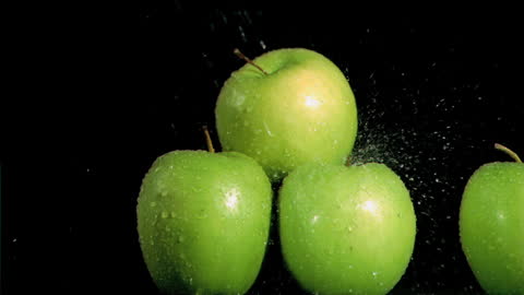 Fresh Green Apples with Water Droplets Against Black Night