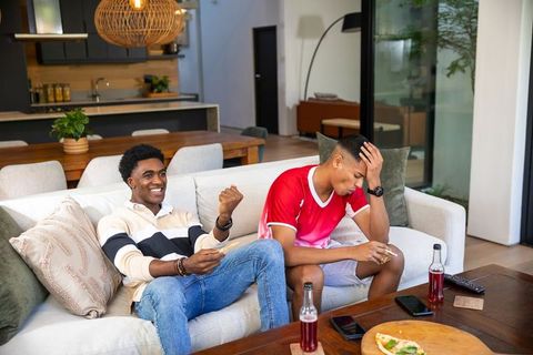 Friends Relaxing in Modern Living Room Watching TV with Pizza