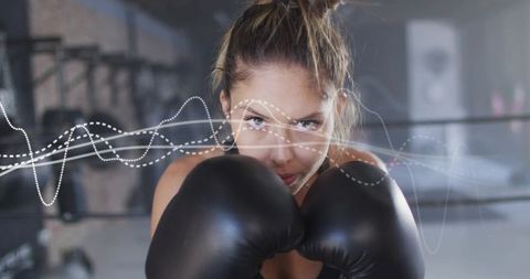 Female boxer training with gloved guard and energy wave overlay in boxing ring