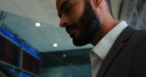 Confident businessman standing on airport escalator with focus on success