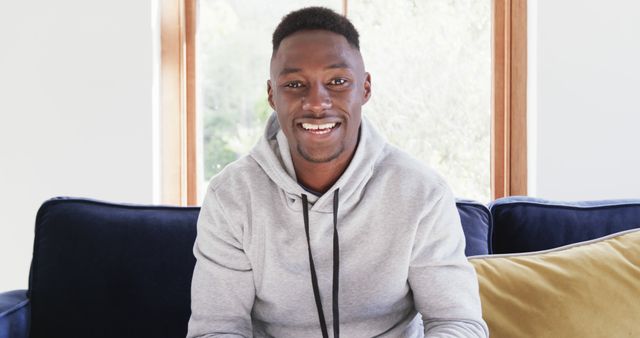 Confident Young Man Smiling While Sitting on Couch - Download Free Stock Images Pikwizard.com