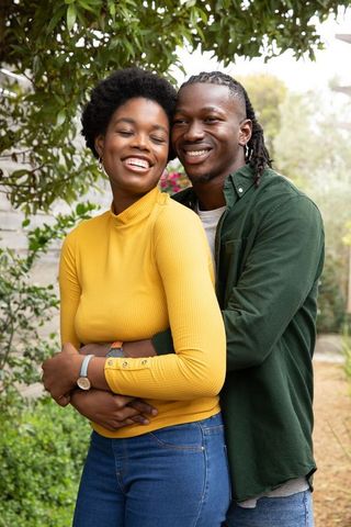 Joyful african american couple hugging in garden