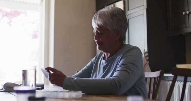 Senior Woman Managing Medications at Home Table During Daytime - Download Free Stock Images Pikwizard.com