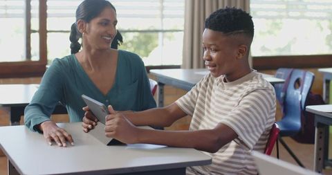 Teacher Assisting Student with Tablet Technology