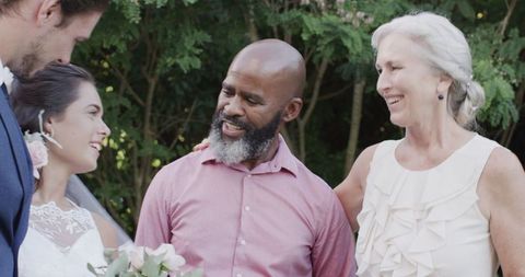 Joyful wedding guests celebrating union outdoors