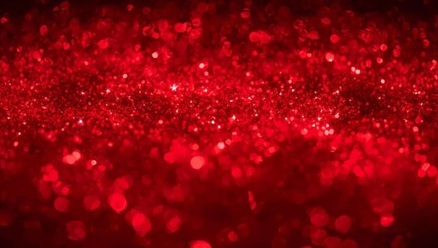 Sparkling red glitter bokeh texture with sequins and shimmering crimson sparkle field