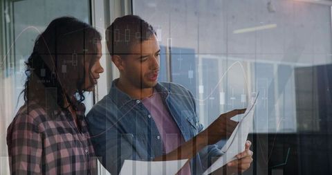 Young professionals reviewing financial reports with transparent analytics overlay