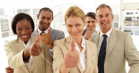 Confident blonde leader guiding diverse business team giving thumbs-up in bright office