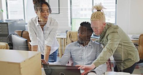 Diverse team collaborating over laptop with digital dashboard overlay in modern office
