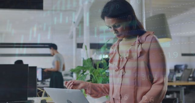 Businesswoman Analyzing Data on Laptop in Office with Financial Graph Overlay - Download Free Stock Images Pikwizard.com