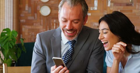 Colleagues Sharing Joyful Moment on Smartphone in Office - Download Free Stock Images Pikwizard.com