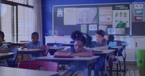 Elementary students concentrating on classwork with girl studying at front-row desk