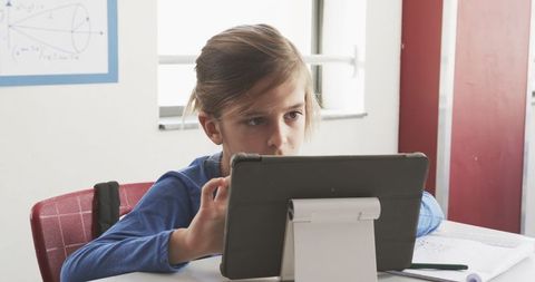 Boy Engaged with Tablet Learning in Classroom Setting