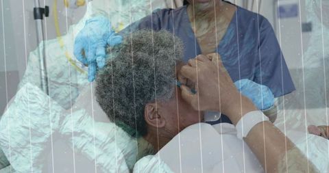 Nurse adjusting nasal cannula for patient with id band in hospital bed, ppe care team