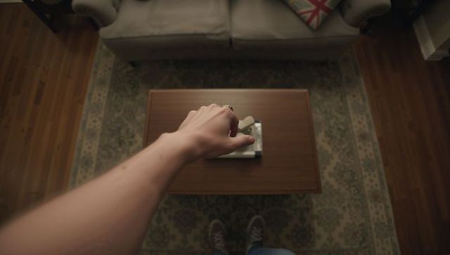 First-person reaching for tray on midcentury coffee table in cozy living room