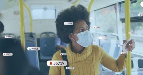 Woman in yellow sweater wearing mask using modern tech on bus