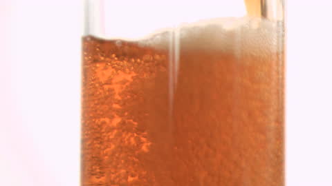 Slow Motion Red Beer Pour with Bubbling Carbonation