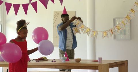 Family Preparing Colorful Decor for Birthday Celebration at Home