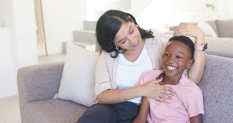 Mother and son sharing joyful moment on sofa building warm family connection at home