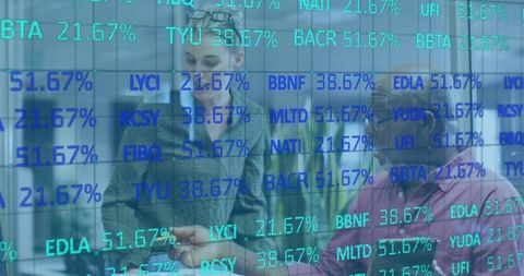 Financial analysts discussing stock figures on digital display