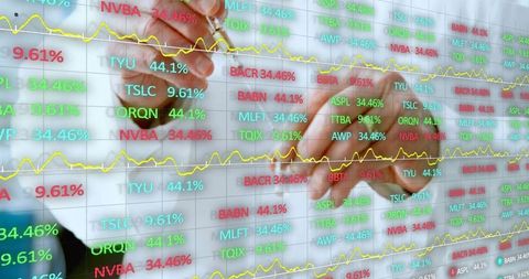 Trader pointing stylus at glass screen showing stock percentages and trend lines
