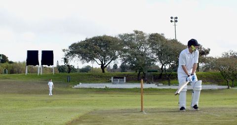 Cricketer Focused on Batting During Outdoor Match