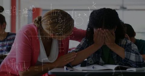 Teacher comforting sad student with math equations