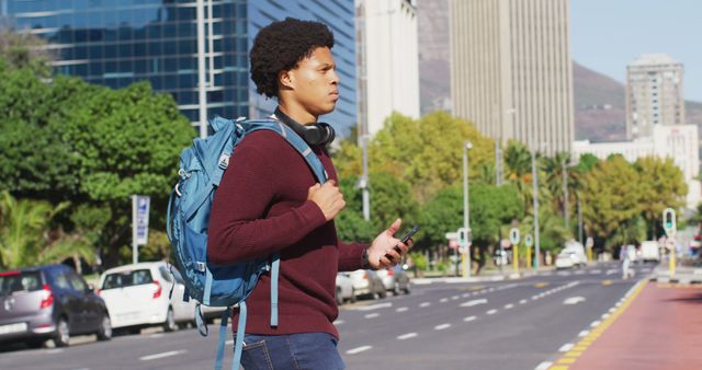 Young Man Walking in Urban City with Backpack and Smartphone - Download Free Stock Images Pikwizard.com