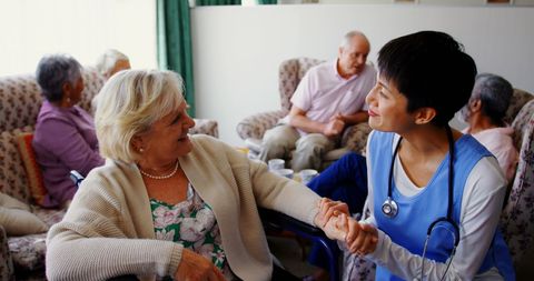 Compassionate Doctor Caring for Elderly Woman in Nursing Home