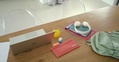 Minimal airy workspace with laptop headphones notebooks and backpack for modern study