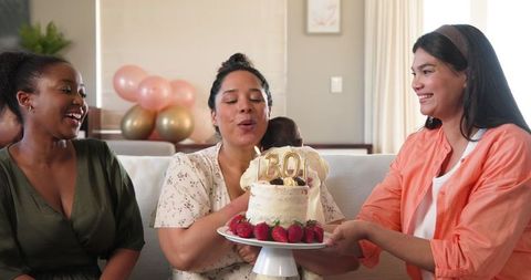 Multiracial Friends Celebrating Birthday with Cake in Living Room