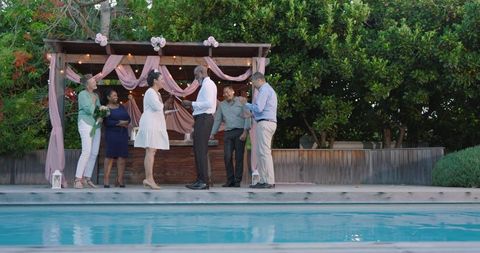 Diverse friends celebrating at poolside evening gathering