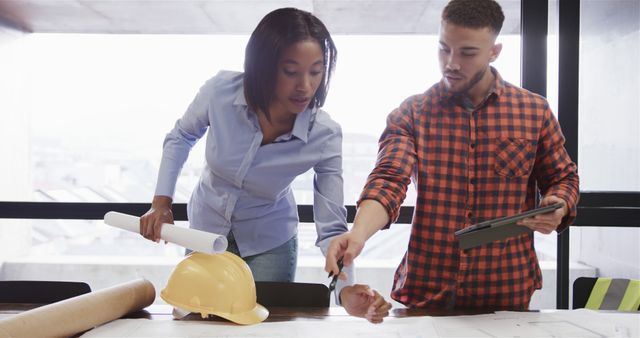 Two Architects Discussing Building Plans at Office Desk - Download Free Stock Images Pikwizard.com