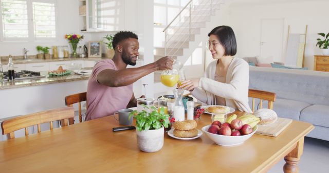 Happy couple enjoying healthy breakfast together in a bright and modern kitchen. Great for advertising lifestyle products, breakfast foods, and healthy living. Use in blogs or articles discussing family life, morning routines, or diet and nutrition tips.
