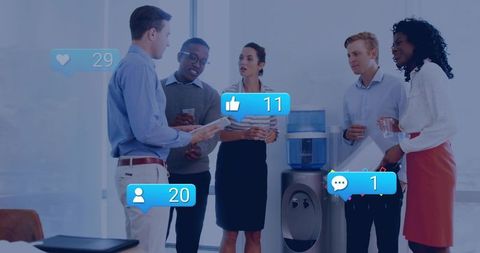 Team interacting by water cooler with social media icons