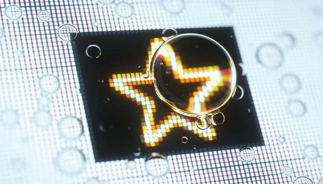 Droplet magnifying multicolor star on backlit display revealing rgb subpixel grid