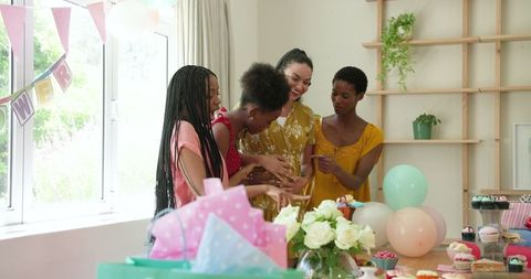 Women Celebrating Baby Shower with Balloons and Gifts in Airy Room