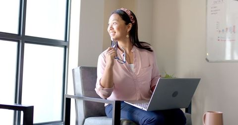 Smiling Businesswoman with Laptop in Modern Office Environment